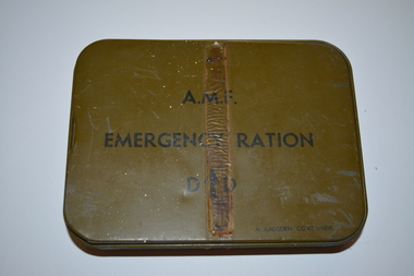 Small khaki colour metal container with ring pull and writing in black ink with detachable lid.