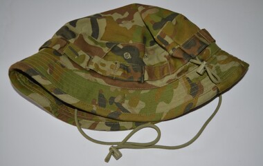 Camouflage fabric hat with short wide brim with loops stitched around band with draw string attached.
