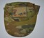 Camouflage fabric cap with vent holes, detachable badge above peaked brim.