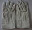 White leather gloves with three rows of stitching on top and snap fasteners attached.