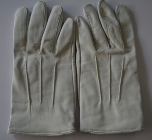 White leather gloves with three rows of stitching on top and snap fasteners attached.