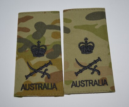 Oblong shaped camouflage fabric epaulettes with three rows of black stitching