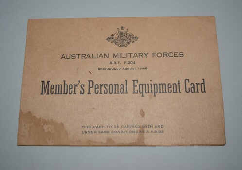 Cream cardboard card fold in half with crest and lettering in black ink on front cover 