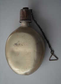 Unpainted aluminium oval shaped water canteen with brownish screw top lip with chain attached.