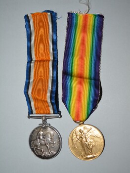 One  bronze and one silver round shaped medals with multi-striped ribbons attached.