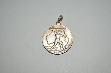 Circular medalet with suspension loop  depicts a knight with sword in front of an outline of Australia with 1945 at the bottom. The reverse shows a map of the southern hemisphere.