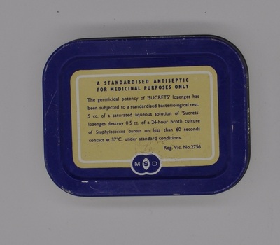 Blue and cream base of the "Sucrets" ten. It has text detailing the ingredients of the lozenges contained within the tin.