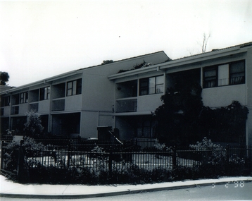 Image of a row of brick double storey townhouses with first floor balconies.