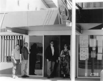 Four people meeting at the front door.