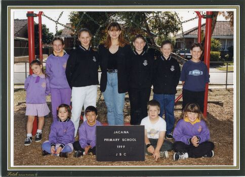 A group of children in two lines in front of climbing frame.