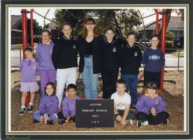 A group of children in two lines in front of climbing frame.