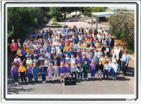 A large group of children standing in the school grounds
