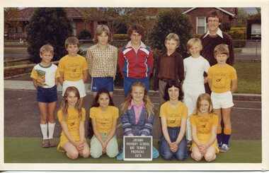 Formal Team Photograph, with children in two rows, the front row is kneeling. There is an adult standing behind the back row on the right.
