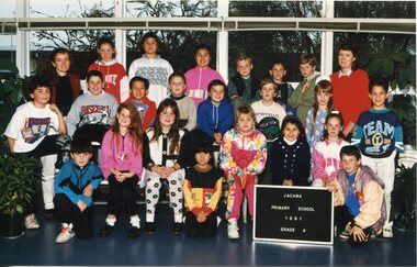 Formal Class Photo with Children in Four Rows, Row 1 is kneeling, Row 2 are seated. An adult is standing with the back row on each side