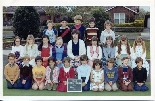 Formal Class photograph, Children are in three Rows, the front Row Kneeling, Centre of the second row is an adult.