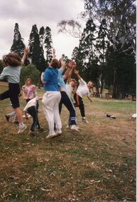 Children in a bunch, Jumping for the football with trees in the background