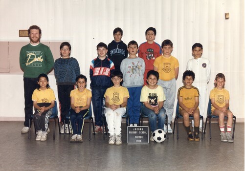 Formal Team Photograph of Children in three rows, the front rows seated. On the left of the second row is an adult standing.