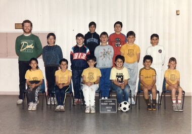 Formal Team Photograph of Children in three rows, the front rows seated. On the left of the second row is an adult standing.