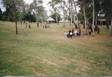 Children playing organised games in the park, with trees in the background