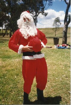 Father Christmas in the park, holding his abdomen