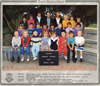 Formal Class Photograph with three children sitting in three rows on wooden benches, with three adults sitting in the centre of the third row. 