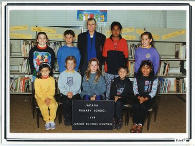 Formal Photograph of Children in two rows, the front row is seated, in the centre of the back row is an adult, standing.