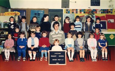 Formal photograph of children in three rows, the front row seated, in the centre of the front row is an adult seated
