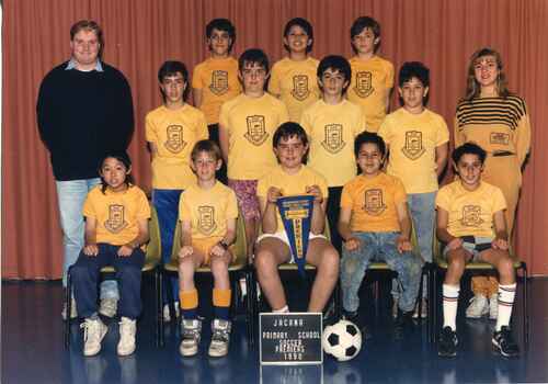 Team Photograph of children in three rows, with adults on each end of the second row. 