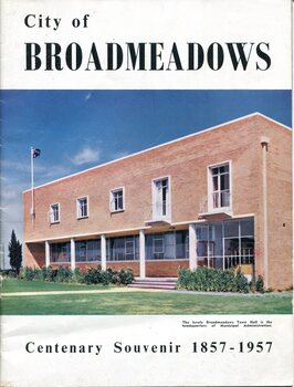 Front cover of City of Broadmeadows: Centenary Souvenir 1857-1957 showing the Broadmeadows Town Hall, a two-storey red-brick municipal building with landscaped grounds and flagpole. Large title text appears above the photograph, with centenary dates displayed below.