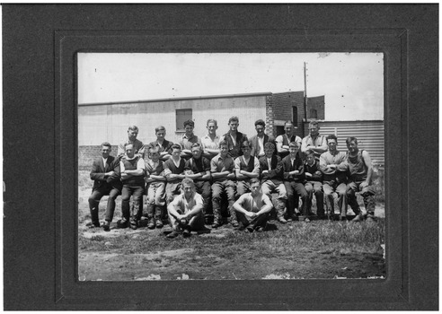 A group photo of the workers at Chelsea Gut Factory, in front of the factory