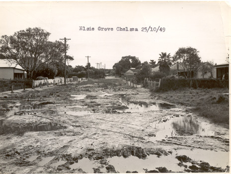 P00091 Elsie Gr Chelsea unmade road after rain 1949