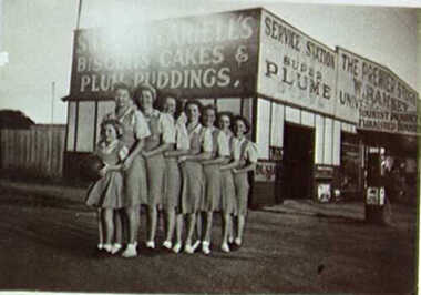 000387 Photograph - c.1945 - Inverloch Basketball team in front of Ramsey's Store - Noelle Muldoon , Rene Ledwidge , Elvie Jacobson , Joyce Gibson , Gwen Muldoon , Lorna - From Noelle Green