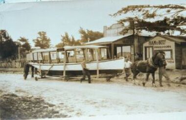 000858 - Photograph - early 1930s - Cal Wyeth's boat West Wind launch - being moved from Pine Lodge on Beach Rd now Ramsey Boulevard - outside Newton's store right- from Hazel Swift