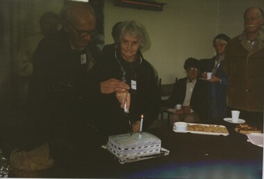 000974 - Photograph - Lyn and Joe Chambers cutting Inverloch Historical Society's 1st birthday cake - July 1997 - Jack Borlase on right - from Nancye Durham