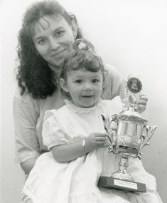 Photograph - Baby Show 1995, Lakes Post Newspaper, Champion Baby Tiah Guillot, holding trophy, with mother Wendy, 1995