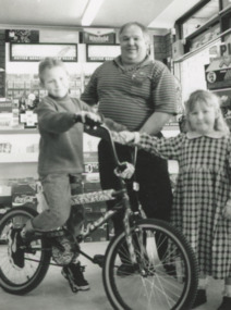 Photograph - Dennis Bassett Manager of Endeavour BP Service Station with winners of Mars Bar Competition Michael and Ashley Solomon Lakes Entrance Victoria, Lakes Post Newspaper, 1/07/1996 12:00:00 AM