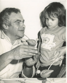 Photograph - Charles Sicura at Art and Craft Show showing Lucy Stanbury a Kiwi Fruit sparrow he made during demonstration at Bairnsdale Fruit Mart Stall Bruthen Victoria, Lakes Post Newspaper, 2/10/1994 12:00:00 AM