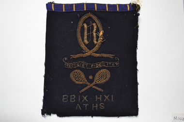 Navy blue wool blazer pocket with embroidered crest and other symbols in metallic gold thread.
