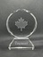 Front of circular glass award with engraving of maple leaf and text