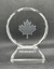 Back of circular glass award with engraving of maple leaf and text