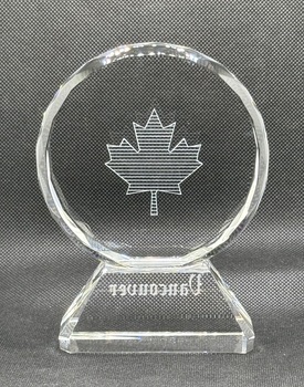 Back of circular glass award with engraving of maple leaf and text