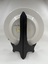 Back of ceramic plate with flower print and an inscription "Happiness is here & now"