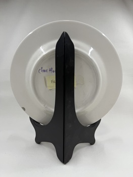 Back of ceramic plate with flower print and an inscription "Happiness is here & now"