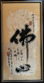 A framed piece featuring artwork on perforated paper, adorned with intricate calligraphy and accented by vibrant red stamps.