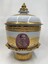 Side of decorative vase with images and inscription