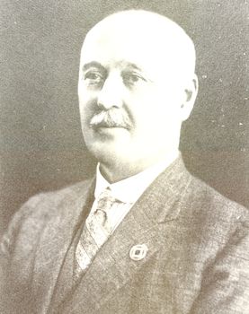 Black and white portrait of a male with bald head and moustache 