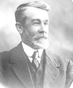 Black and white Formal portrait of James Goldie with a neat short beard 