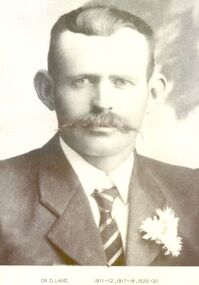 Black and white portrait of Councillor D Lane with a flower in his left lapel