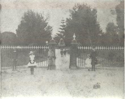 People in several groups outside the entrance gates to the botanical gardens