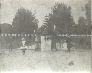 People in several groups outside the entrance gates to the botanical gardens